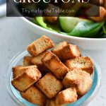 Crispy croutons in a small glass bowl with the text, air fryer croutons.