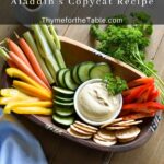 A platter with yellow peppers, red peppers, carrots, celery, cucumbers, crackers and hummus and text: Hummus Aladdin's Copycat Recipe.