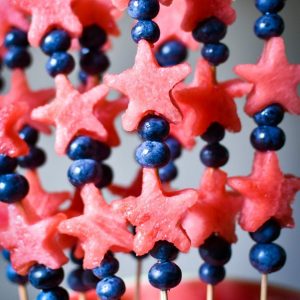 Watermelon stars and blueberries on several wooden skewers.