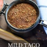 All the mixed spices in a small container with the text: mild taco seasoning.