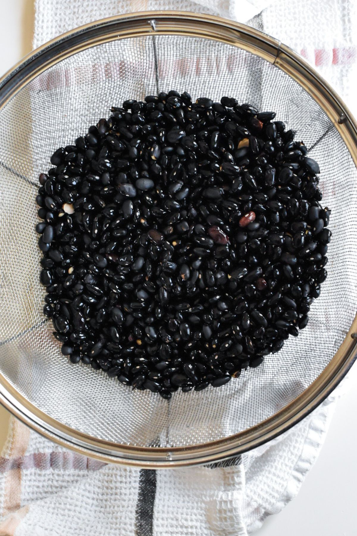 Rinsed dried black beans in a colander.
