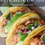 Chicken tacos on a wood board with the text: Instant Pot Chicken Tacos.