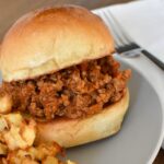 A sloppy joe on a plate with french fries