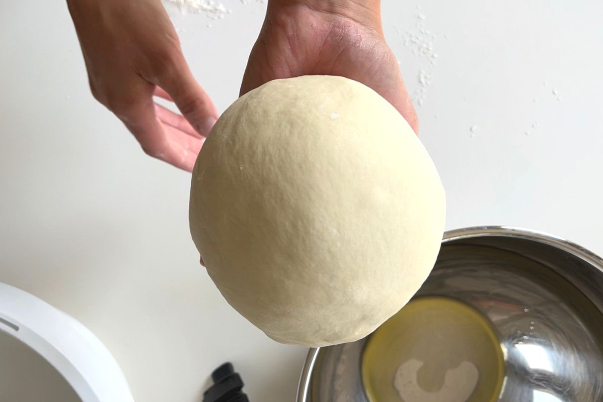 A smooth ball of dough in a hand.