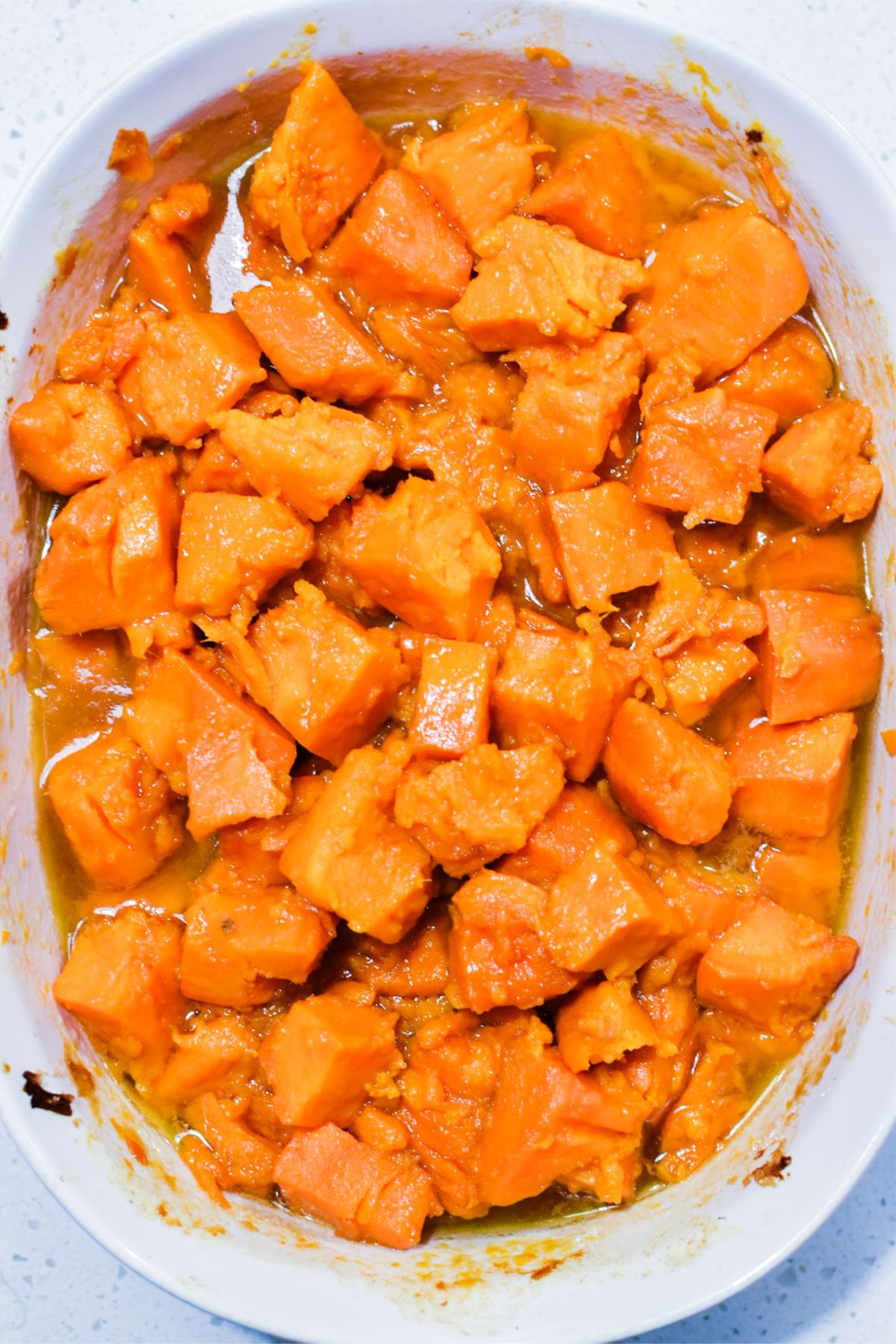 Cooked sweet potatoes in a white casserole dish.
