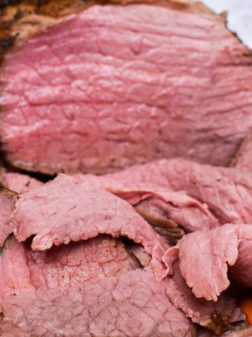 Thin slices of eye of round roast with the remaining roast behind it.