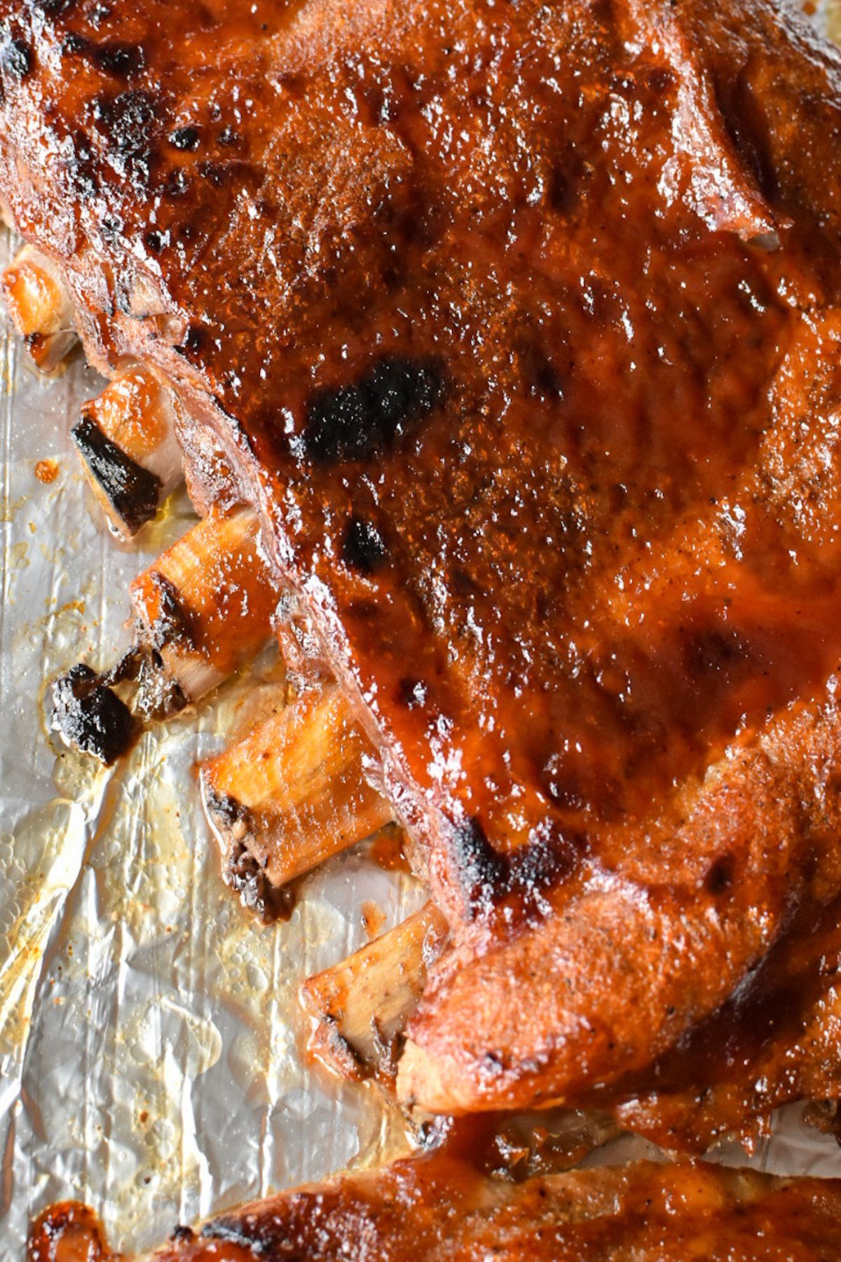 A close-up of the cooked rib meat pulling away from the end of the rib bones.