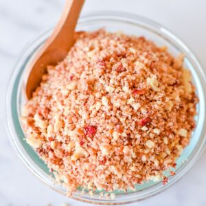 Strawberry shortcake crunch in a small bowl with a small wooden spoon in it.