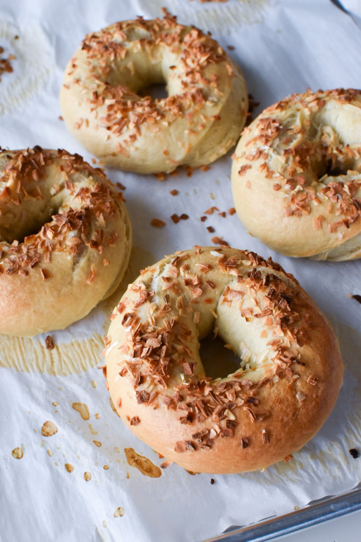 Cooked onion bagels on parchment paper.