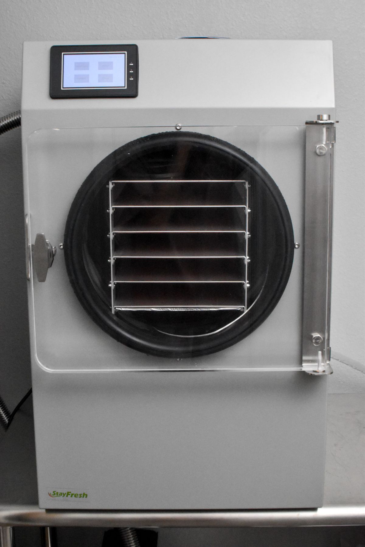 A Stay Fresh Brand freeze dryer on a metal table.