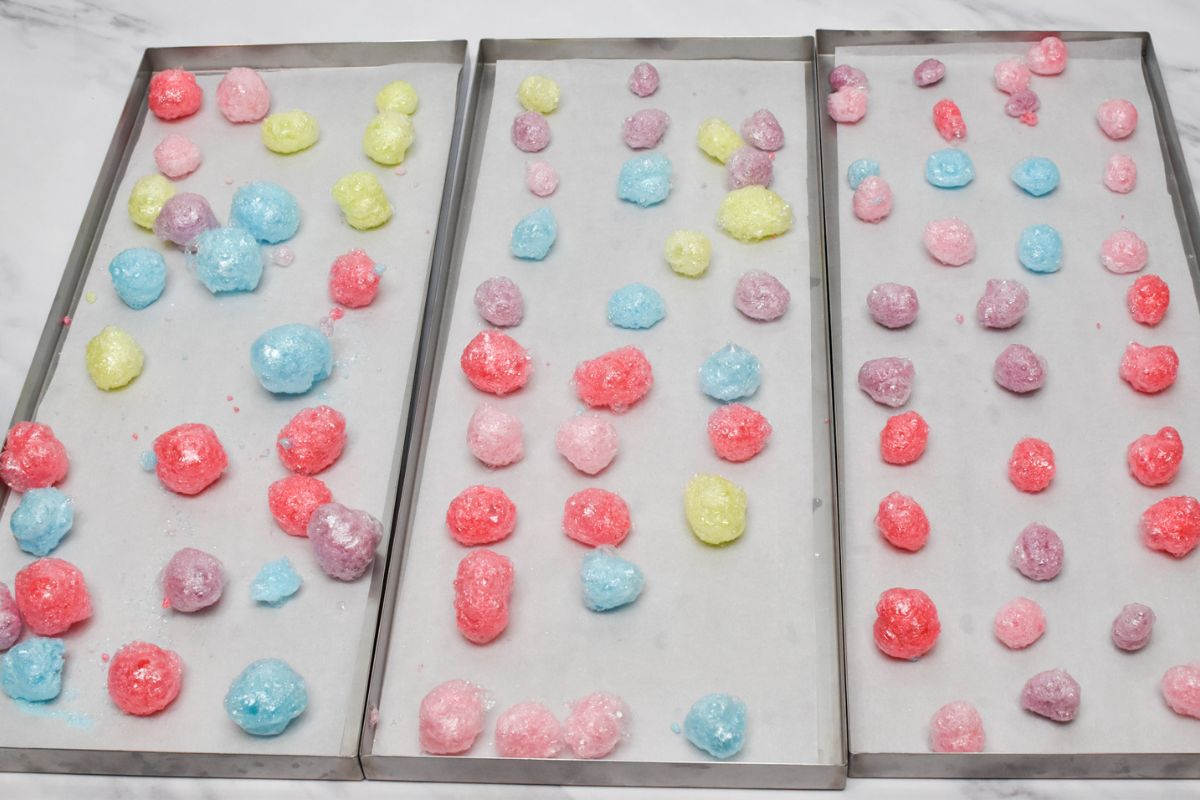 Three freeze dryer trays with puffed up freeze dried jolly ranchers on them.