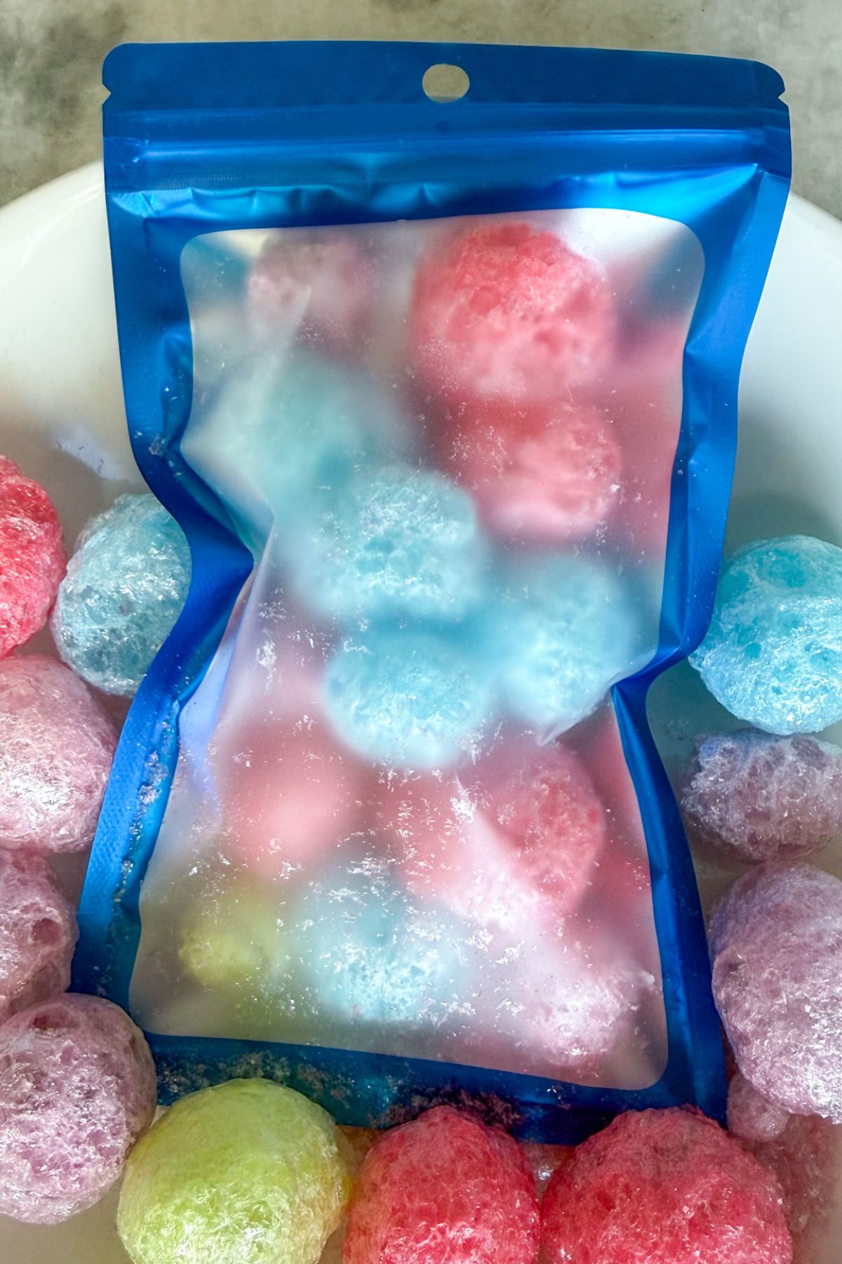 Freeze dried Jolly Ranchers in a mylar bag with more Jolly Ranchers around the outside of the bag.