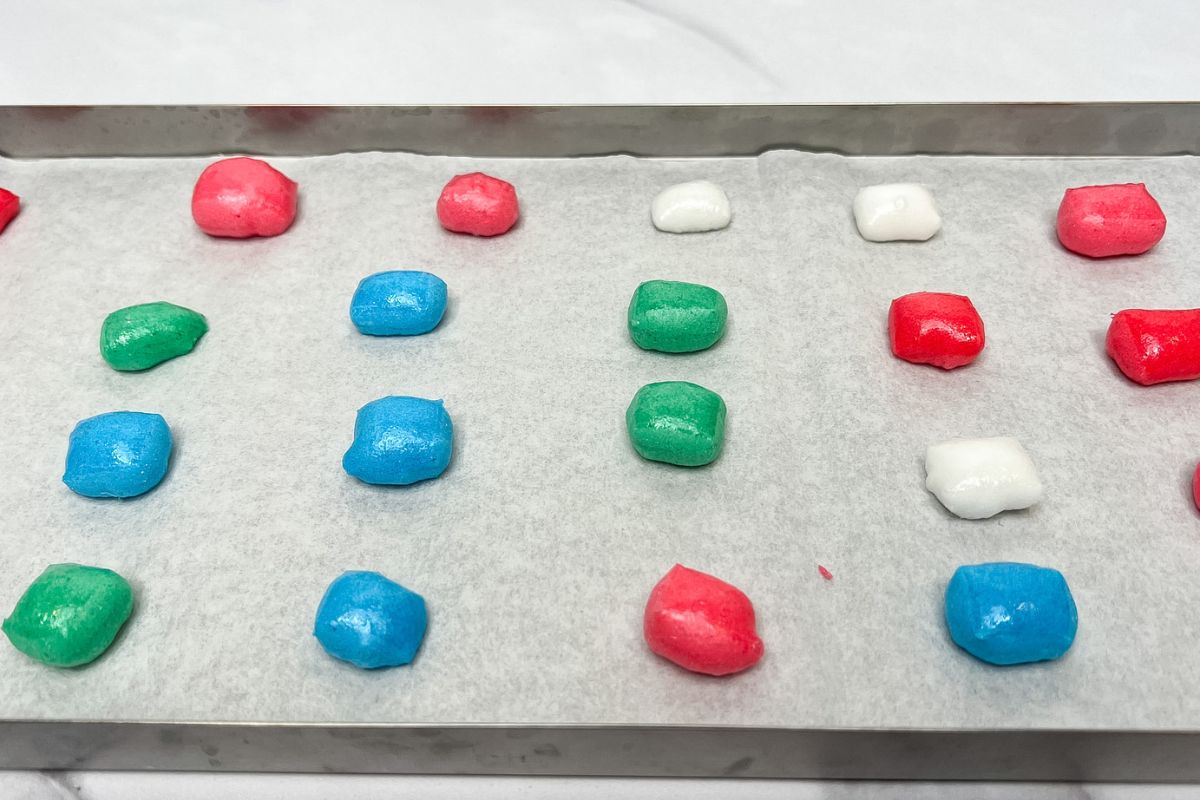 Puffed up freeze dried Airheads on a parchment lined freeze dryer tray.