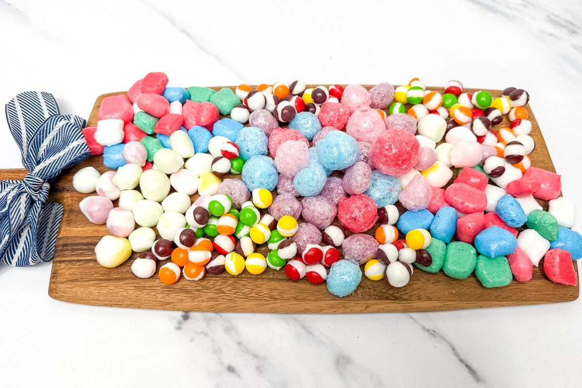 A wooden board with freeze dried Airheads, Skittles and Jolly Ranchers on it.