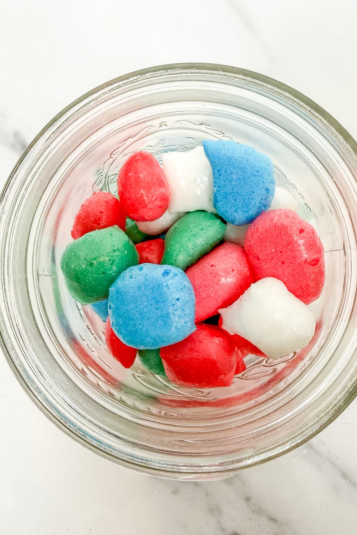 A glass jar with freeze dried Airheads in it.