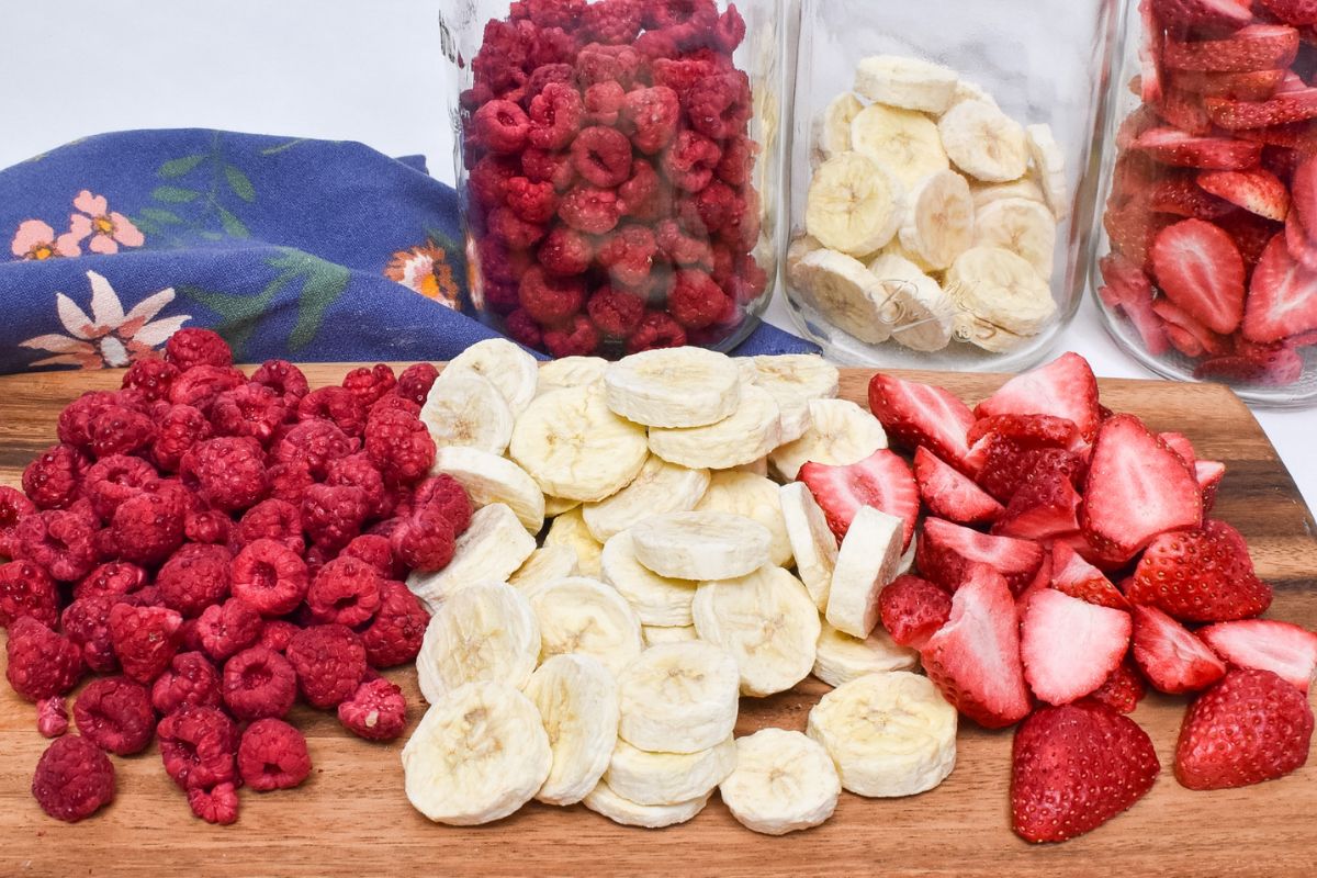 A wooden board with freeze dried raspberries, bananas, and strawberries.