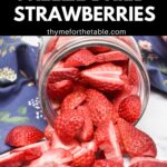 A glass mason jar laying on it's side with freeze dried strawberries spilling onto the counter with the text: how to make freeze dried strawberries.
